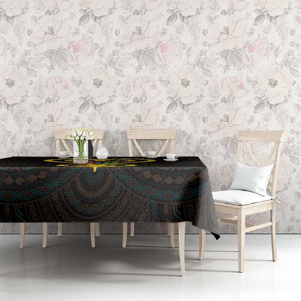 Black tablecloth with gold heart graphic and multicolor Adinkra-style motifs on dining table