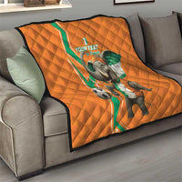 Orange quilt on gray couch with elephant football design and green-white trim