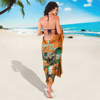 Orange elephant-print sarong with green flag, worn around the waist