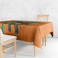 Orange tablecloth with elephant graphic and green accent border over a dining table