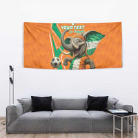Orange football tapestry with baby elephant in green-and-white jersey and soccer ball, cropped.