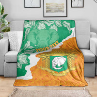 Custom throw blanket on sofa with Ivory Coast map, green/orange elephant crest