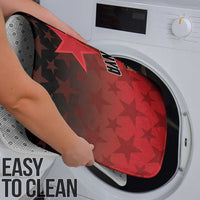 Red star-pattern bathroom mat being cleaned near a washing machine door