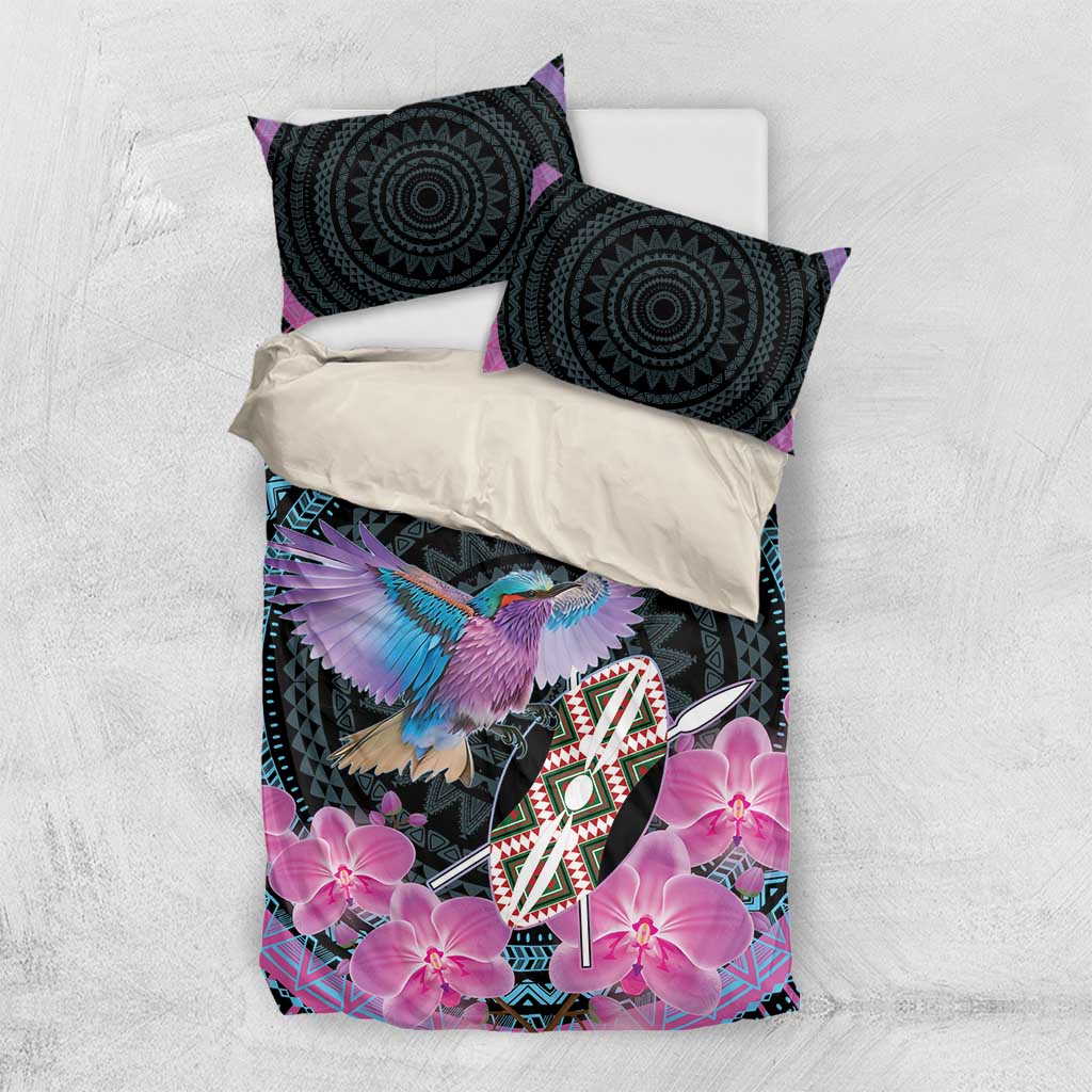 Purple and black bedding set laid flat with two round-pattern pillows and pink orchid print