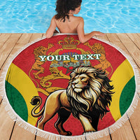 Round beach blanket featuring a lion and crown graphic in red, yellow, and green with fringe