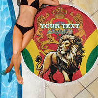 Round beach blanket with lion and crown graphic in red, yellow, and green, white fringe trim
