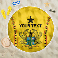 Circular yellow beach blanket with black star crest, 'YOUR TEXT' print, and white fringe.