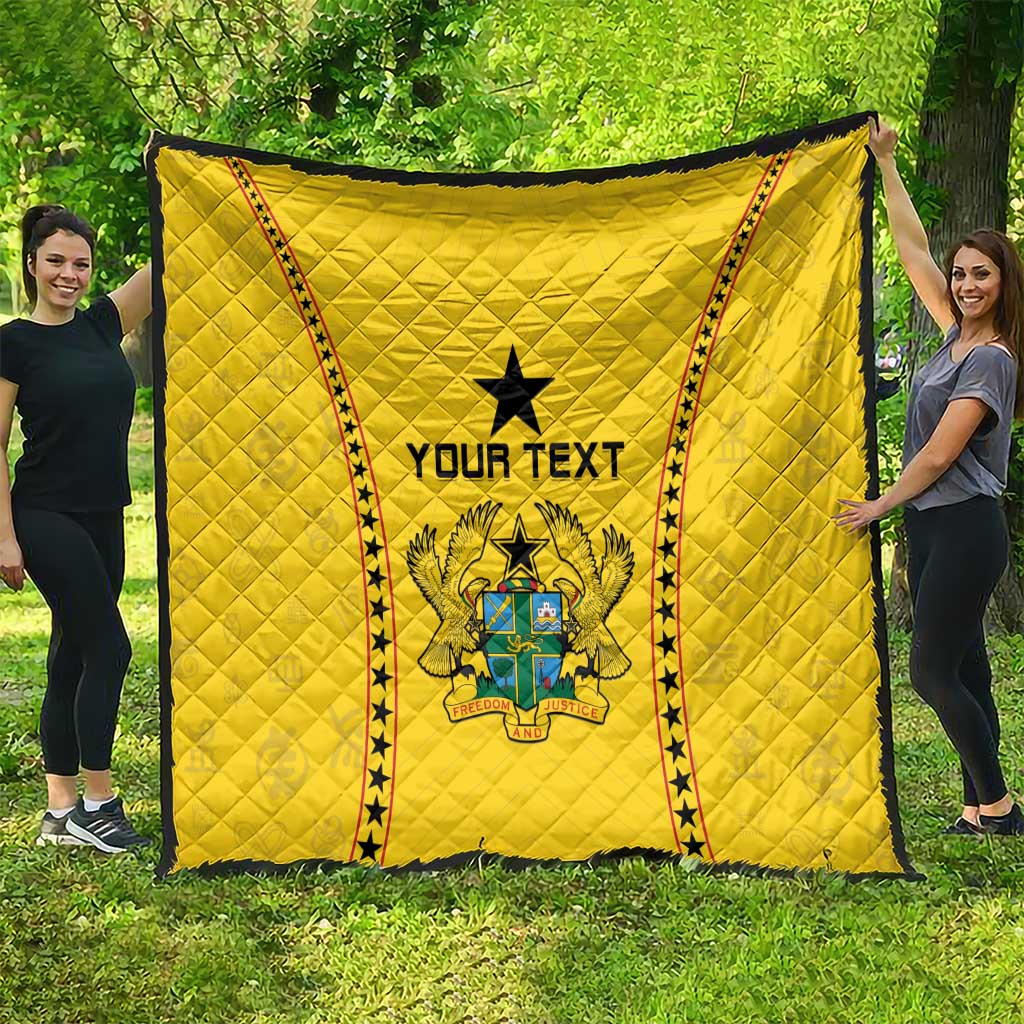 Yellow Ghana quilt draped outdoors, black star and crest with 'YOUR TEXT' center.