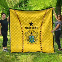 Yellow Ghana quilt draped outdoors, black star and crest with 'YOUR TEXT' center.
