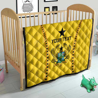 Yellow quilt on crib, black star and Ghana crest with 'YOUR TEXT', red star trim.