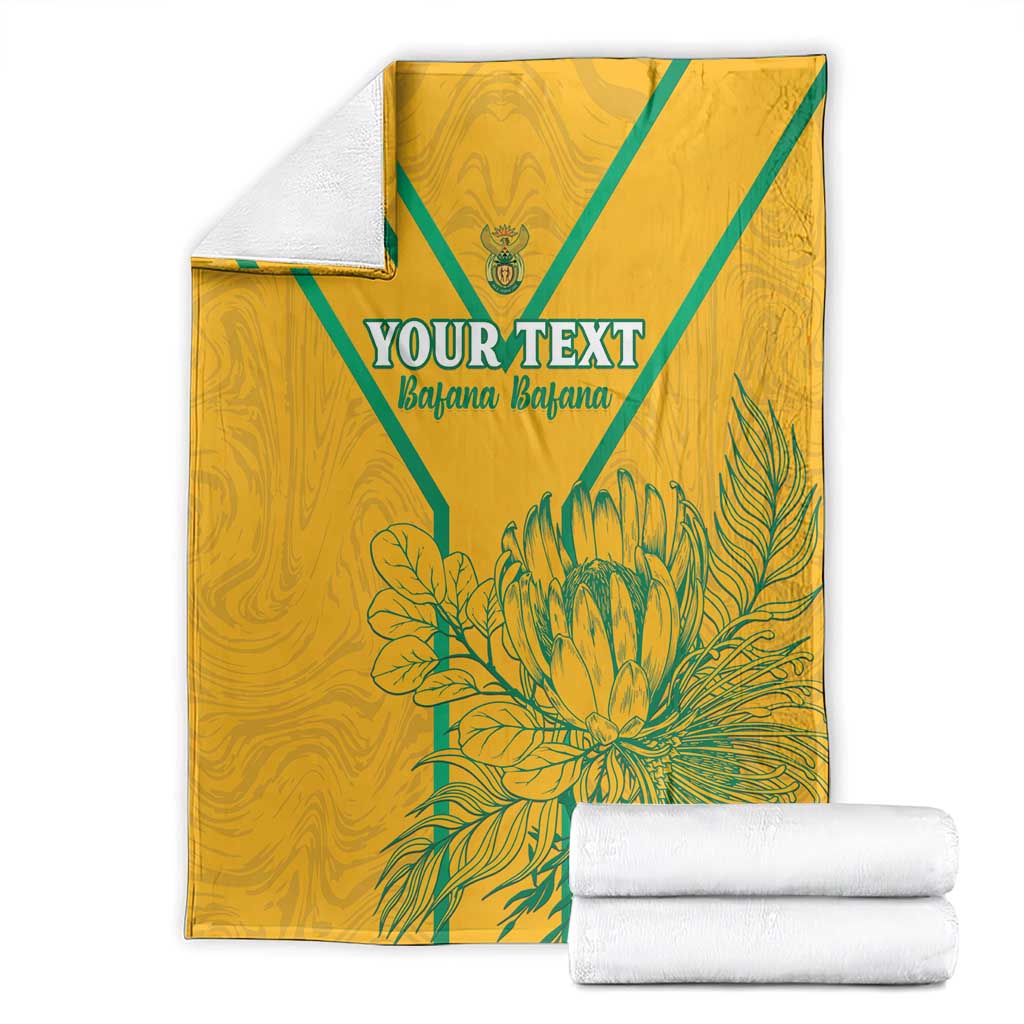 Folded yellow custom soccer blanket with teal diagonal stripes, 'YOUR TEXT' and floral print