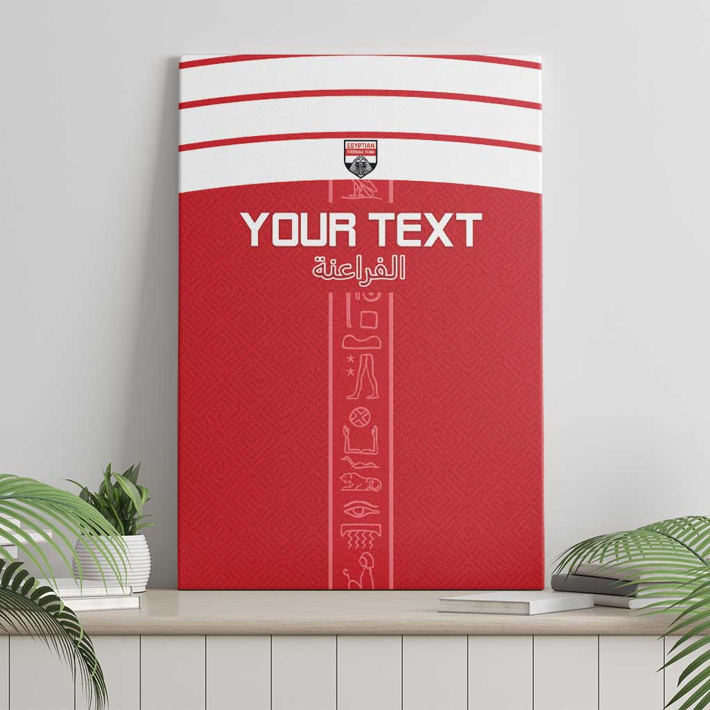 Red canvas wall art with white top stripes, shield logo, and vertical hieroglyph design