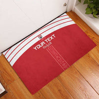 Red custom rubber doormat with white stripes, “Your Text,” and decorative Egyptian symbols