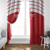 Red window curtain panels with white arched stripes, tied at center over a window.