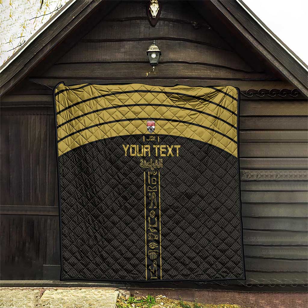 Black custom football quilt hanging indoors with gold stripes and vertical emblem panel