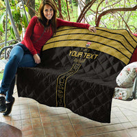 Black and gold custom football quilt draped on a couch with vertical emblem detail