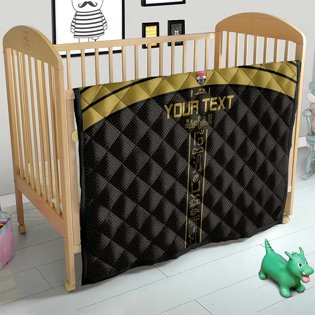 Custom black and gold football quilt on a crib with vertical emblem and gold stripes