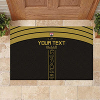 Black rubber doormat with yellow border, custom text and pharaoh-style emblem in center