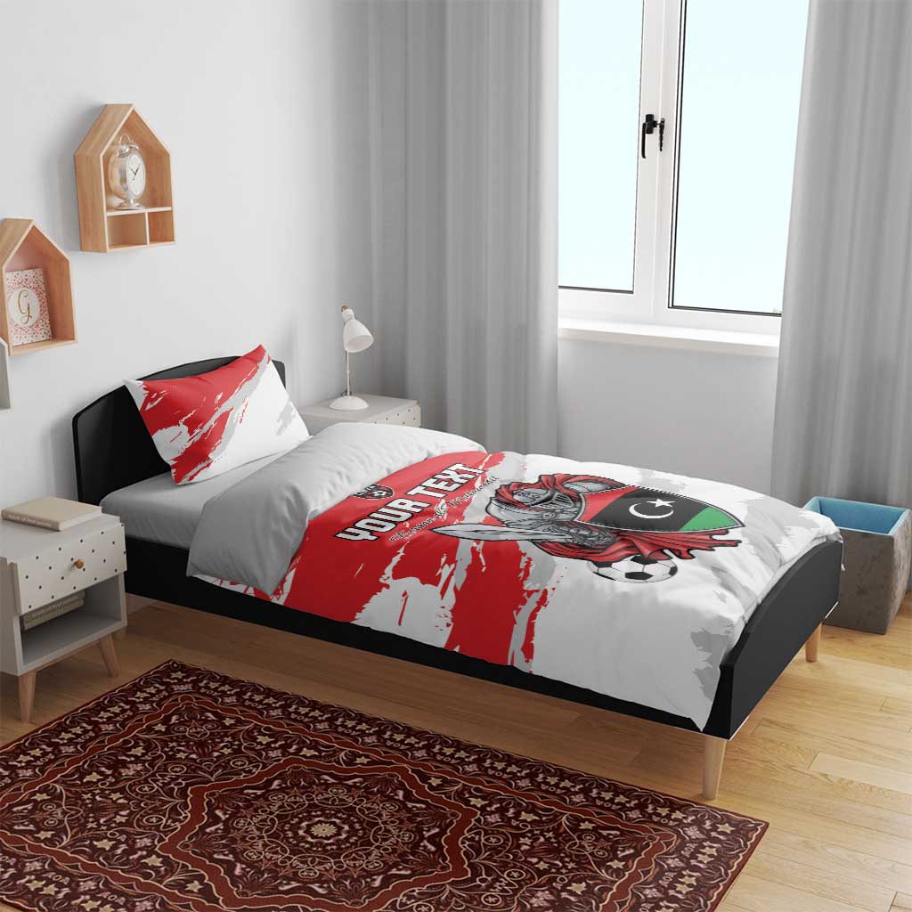 Red and white bedding set on bed with two pillowcases, Libya emblem and football graphic
