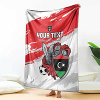 Custom football blanket draped on floor, red flag-style top with shield and soccer art