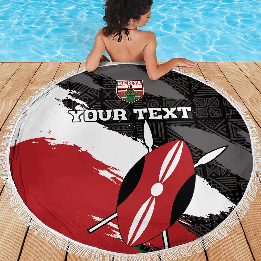 Round fringe beach blanket on wooden deck in black, white, red with surfboard design