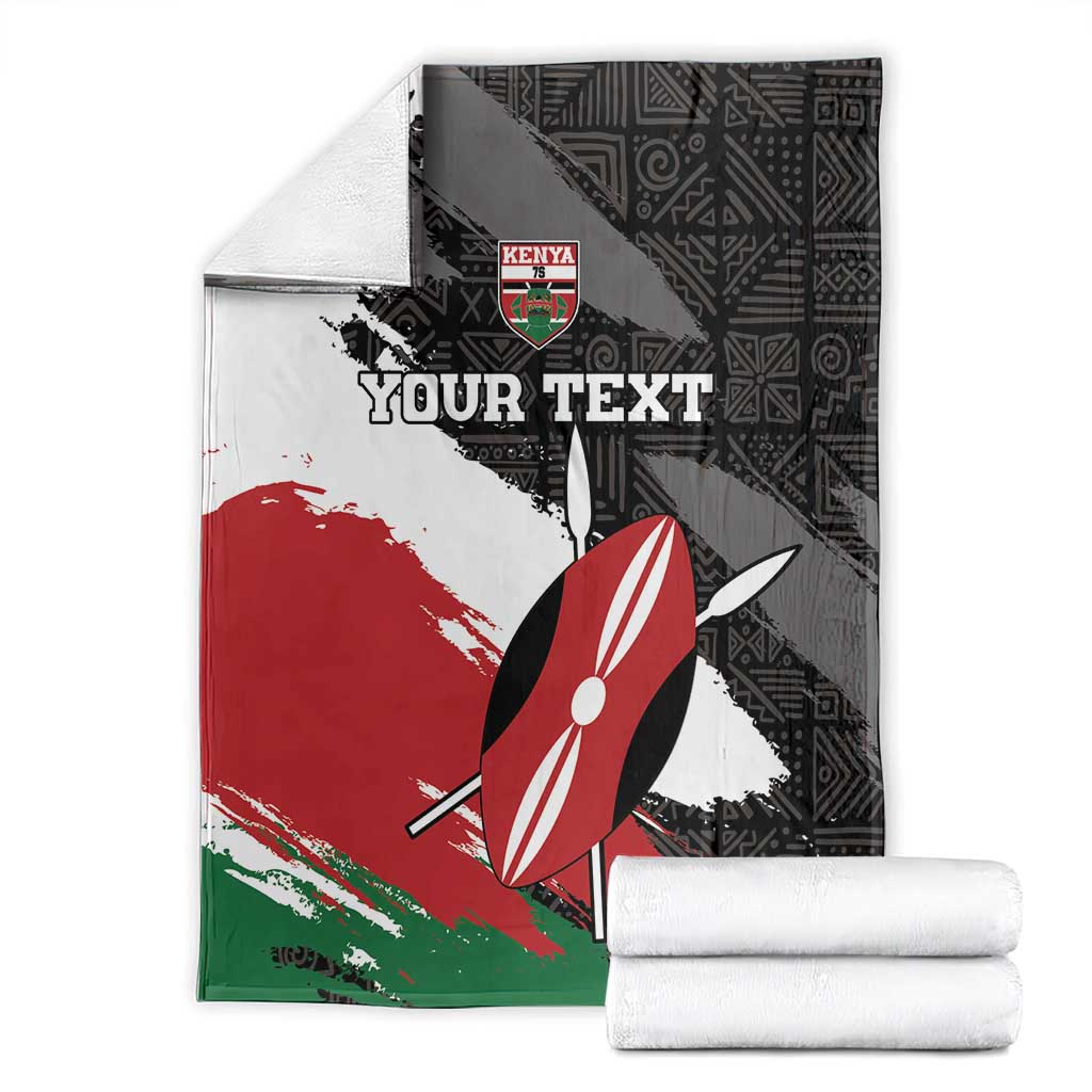 Kenya rugby blanket folded: black geometric print with red, white, green stripes and umbrella