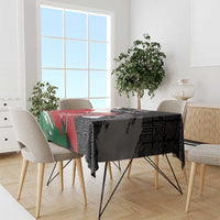 Black tablecloth with African geometric pattern in red and green, draped over dining table