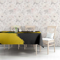 Yellow and black grunge tablecloth with diagonal brush pattern, covering a dining table.