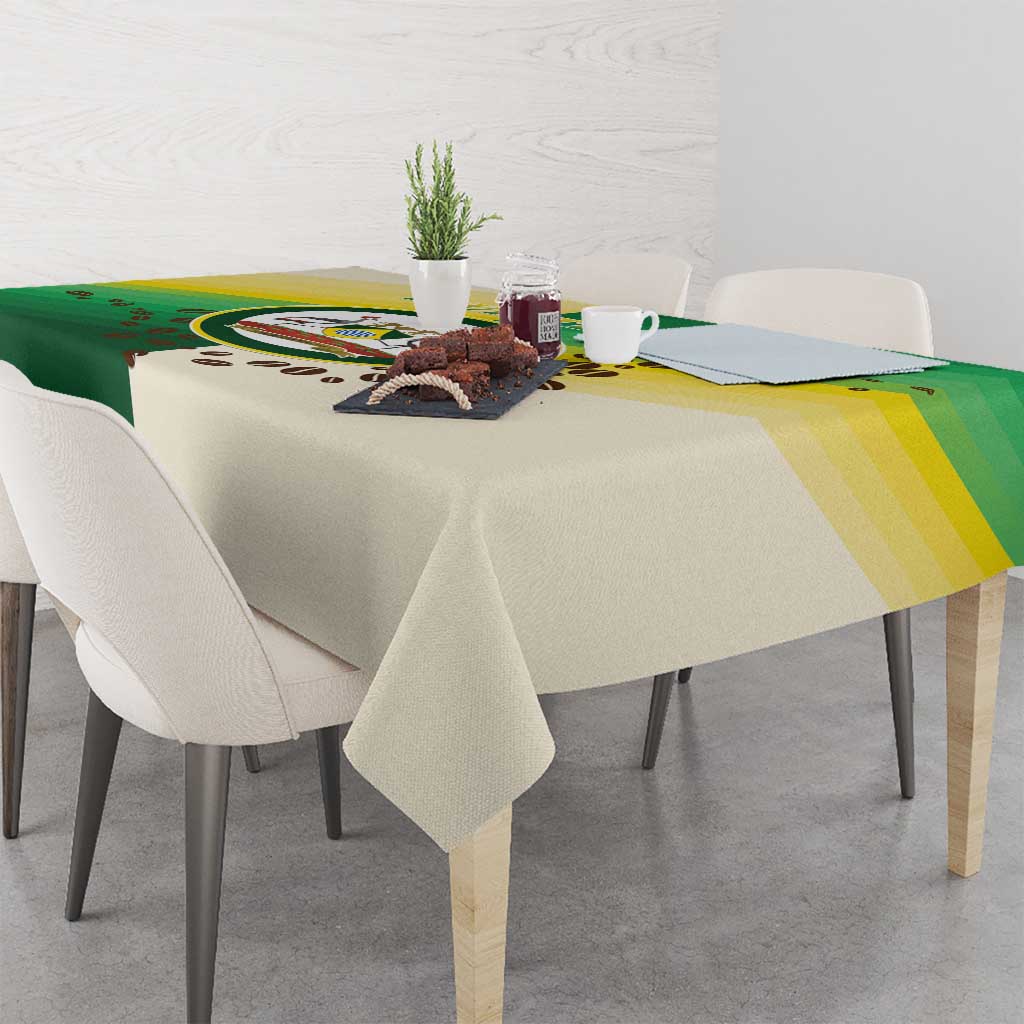 Corner view of green and cream Nairobi tablecloth with circular emblem and striped band
