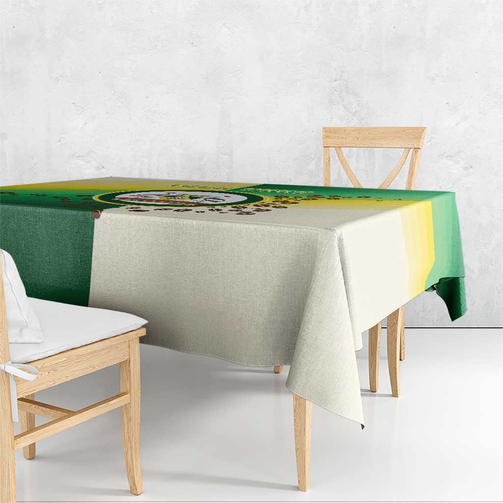 Green and cream Nairobi tablecloth with circular emblem, draped over table edge