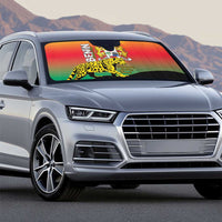 Auto sun shade on silver car with Benin coat of arms and leopard print in rainbow colors