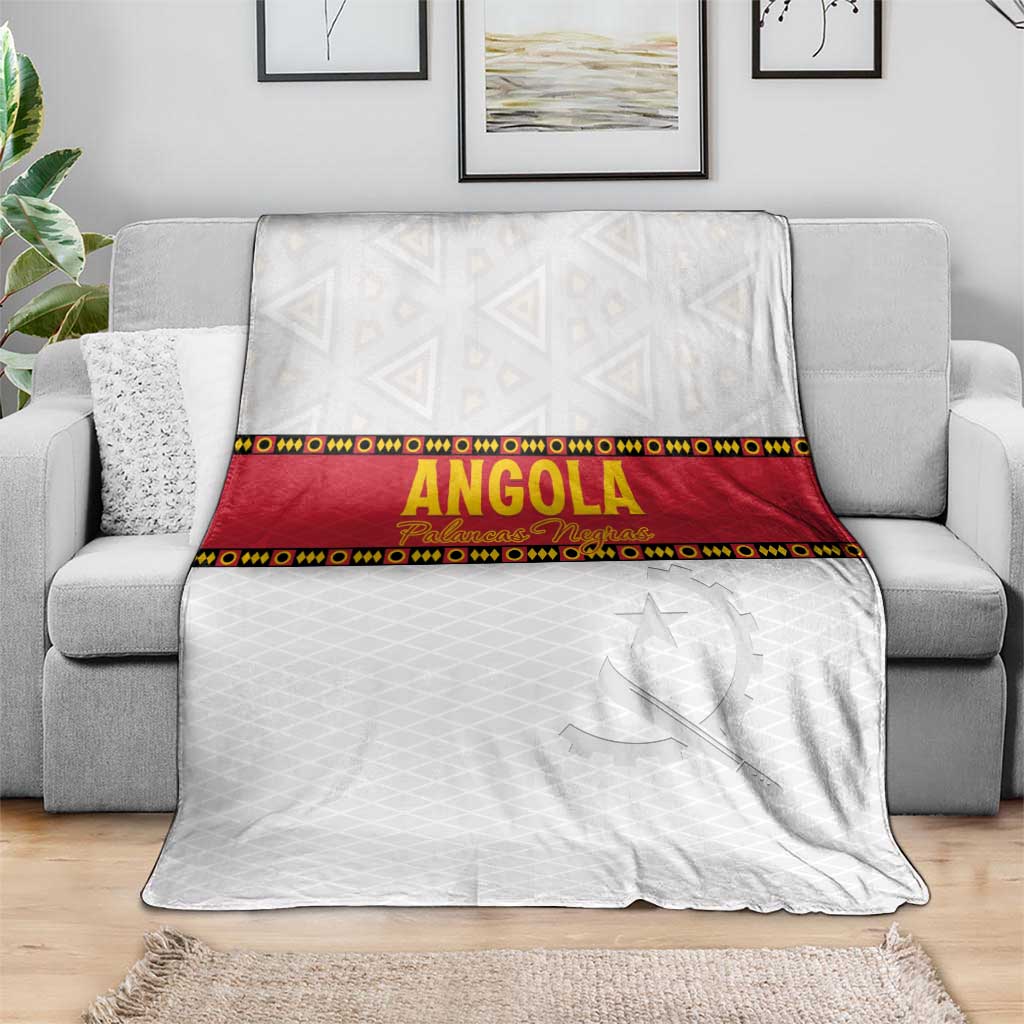 Angola football blanket spread on gray couch, white with red band and star motif