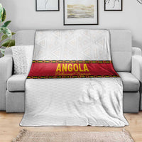 Angola football blanket spread on gray couch, white with red band and star motif