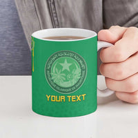 Green ceramic mug held in hand with Islamic circular crest and gold “YOUR TEXT”
