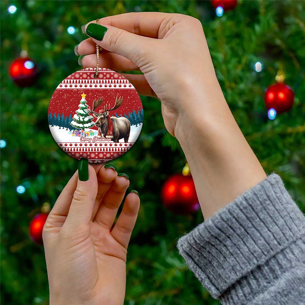 Red ceramic circle ornament with reindeer and Christmas tree scene, gold hanger in hand