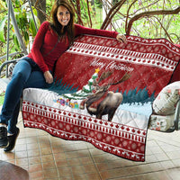 Red Christmas quilt with moose and 'Merry Christmoose' text, spread across outdoor seating