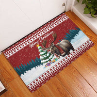 Corner view red rubber Christmas doormat with reindeer, snow scene, and border.