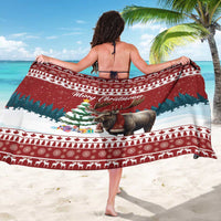 Red Christmas sarong draped over shoulders, featuring reindeer and festive border patterns