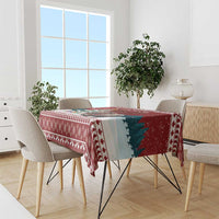 Red Christmas tablecloth draped on dining table with festive border pattern