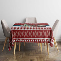 Red Christmas tablecloth on dining table with repeating icons and patterned trim