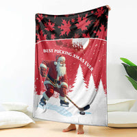 Red and white blanket showing Santa hockey player with pine trees and maple leaf pattern