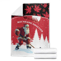 Folded red Christmas blanket with Santa hockey player, pine trees, and maple leaf motif