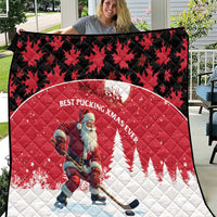 Red quilt blanket with Santa hockey player in center and black maple-leaf border.