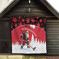 Red and white quilt hanging with Santa hockey player, black maple-leaf border top.