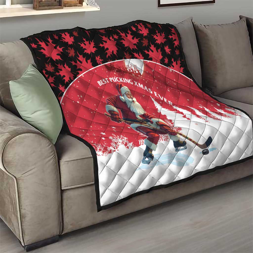 Red and white quilt on sofa with Santa hockey player and pine tree silhouettes.