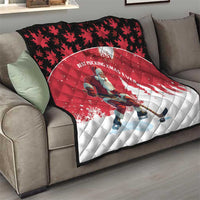 Red and white quilt on sofa with Santa hockey player and pine tree silhouettes.