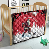 Red and white quilt on crib with Santa hockey player, black maple-leaf border.