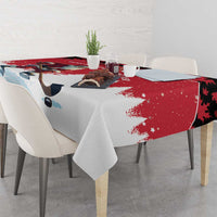 Red and white tablecloth over dining table with Santa, pine trees, and snowflake accents