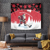 Red holiday wall tapestry with Santa hockey on snow, snowy pine trees, black leaf pattern border.