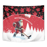 Close-up red holiday wall tapestry with Santa hockey on snow and pine trees, black leaf frame.